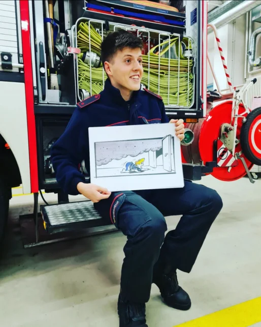 Präsentation Junger Feuerwehrmann präsentiert Schaubild das die Entwicklung des Rauches im Raum demonstriert
